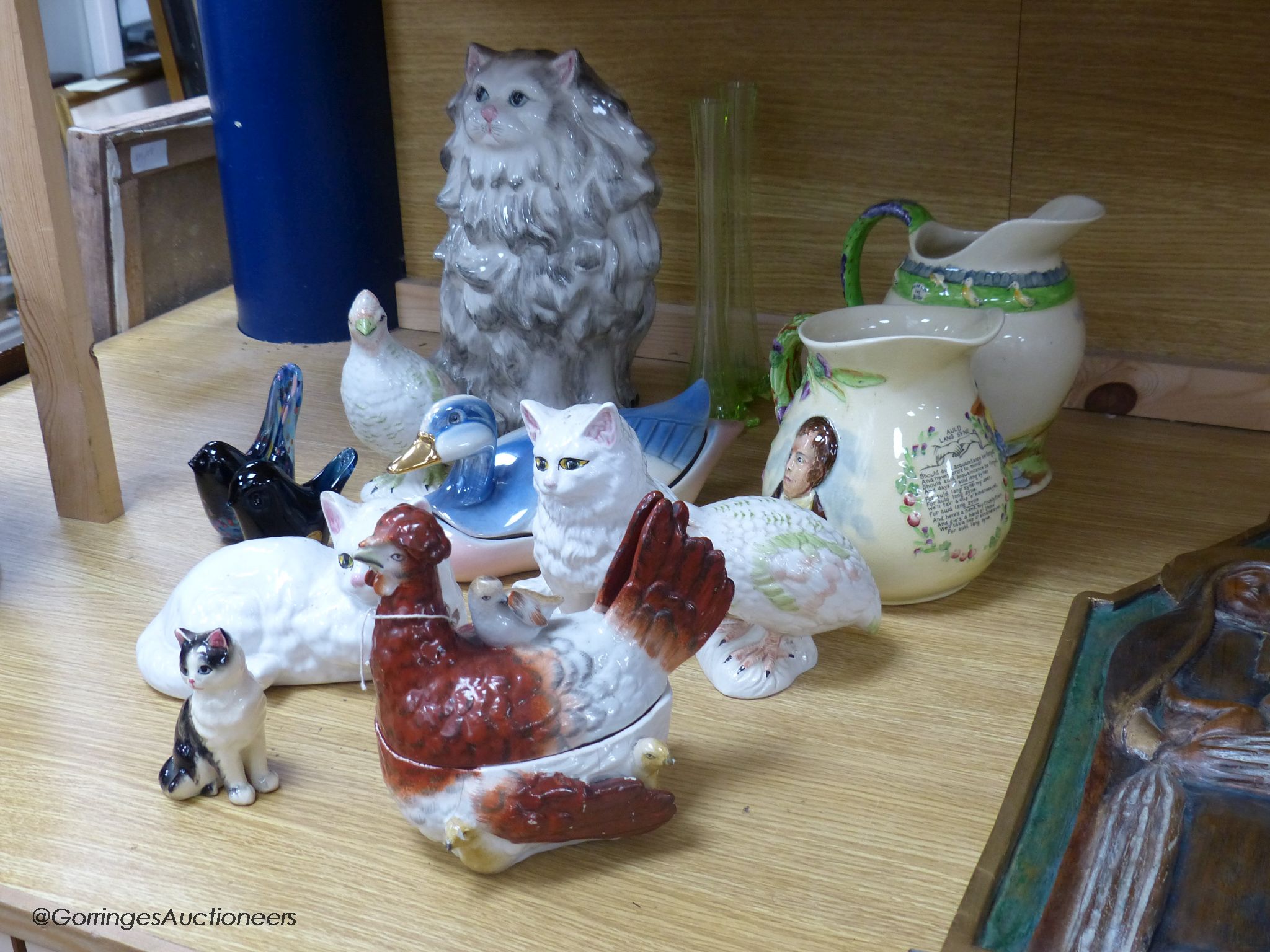 Two Crown Devon musical jugs and various pottery animals including a Staffordshire hen box and two glass 'bird' paperweights, tallest 29cm